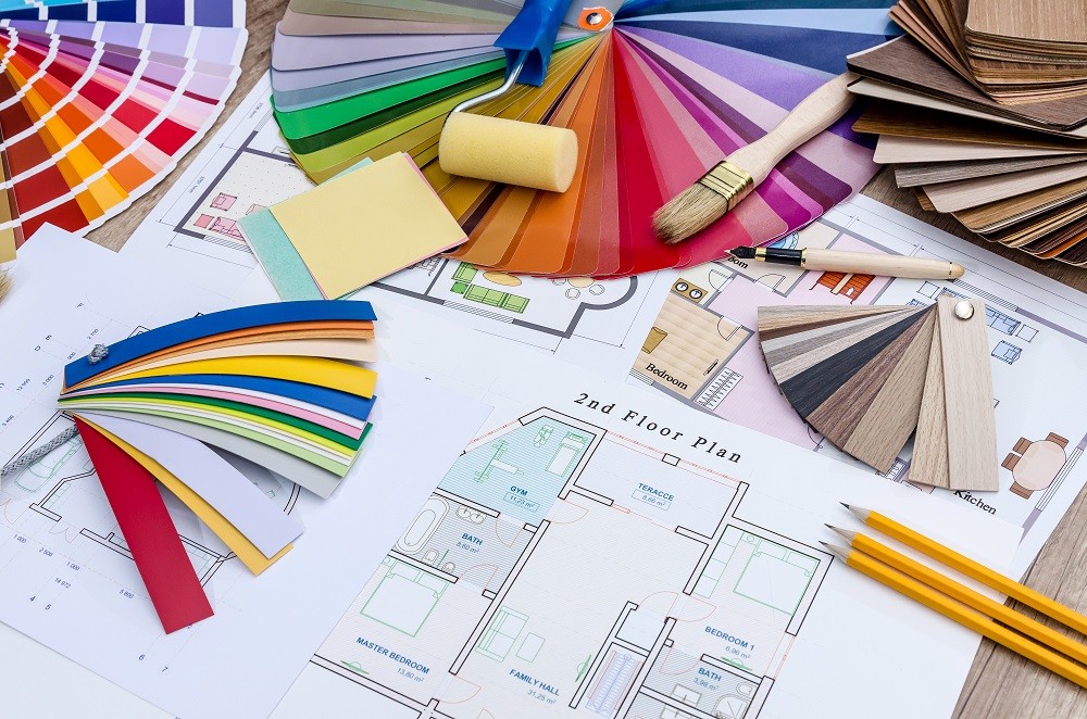 On the table lay the house plan, colored and wooden designs, work tools On the table lay the house plan, colored and wooden designs, work tools